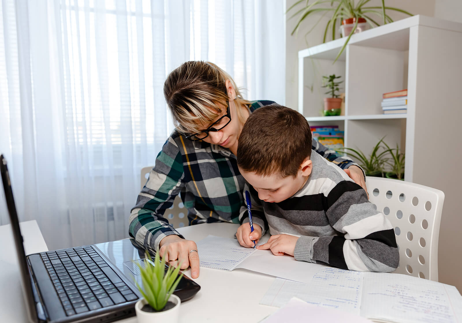 Madre e hijo estudiando en casa gracias al homeschooling.