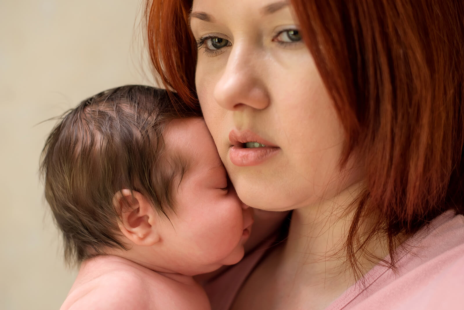 Mujer con su recién nacido en casa sufriendo depresión porque se queda en casa.