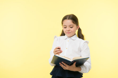 Niña escribiendo en su agenda escolar.