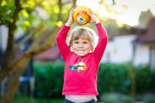 Niña feliz jugando con una pelota.