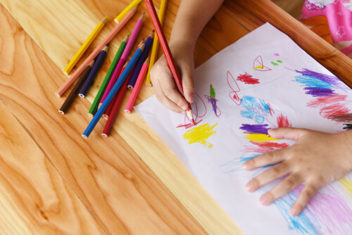 Niña haciendo un dibujo con colores.