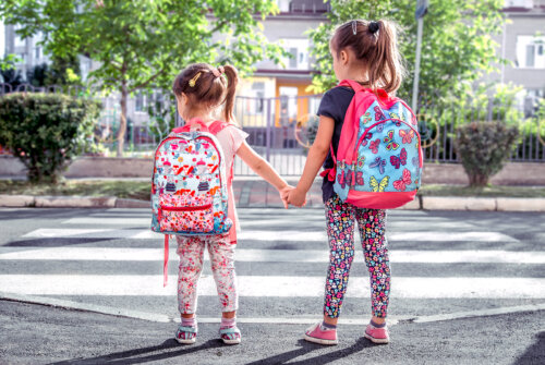 Niñas yendo al colegio con sus mochilas.