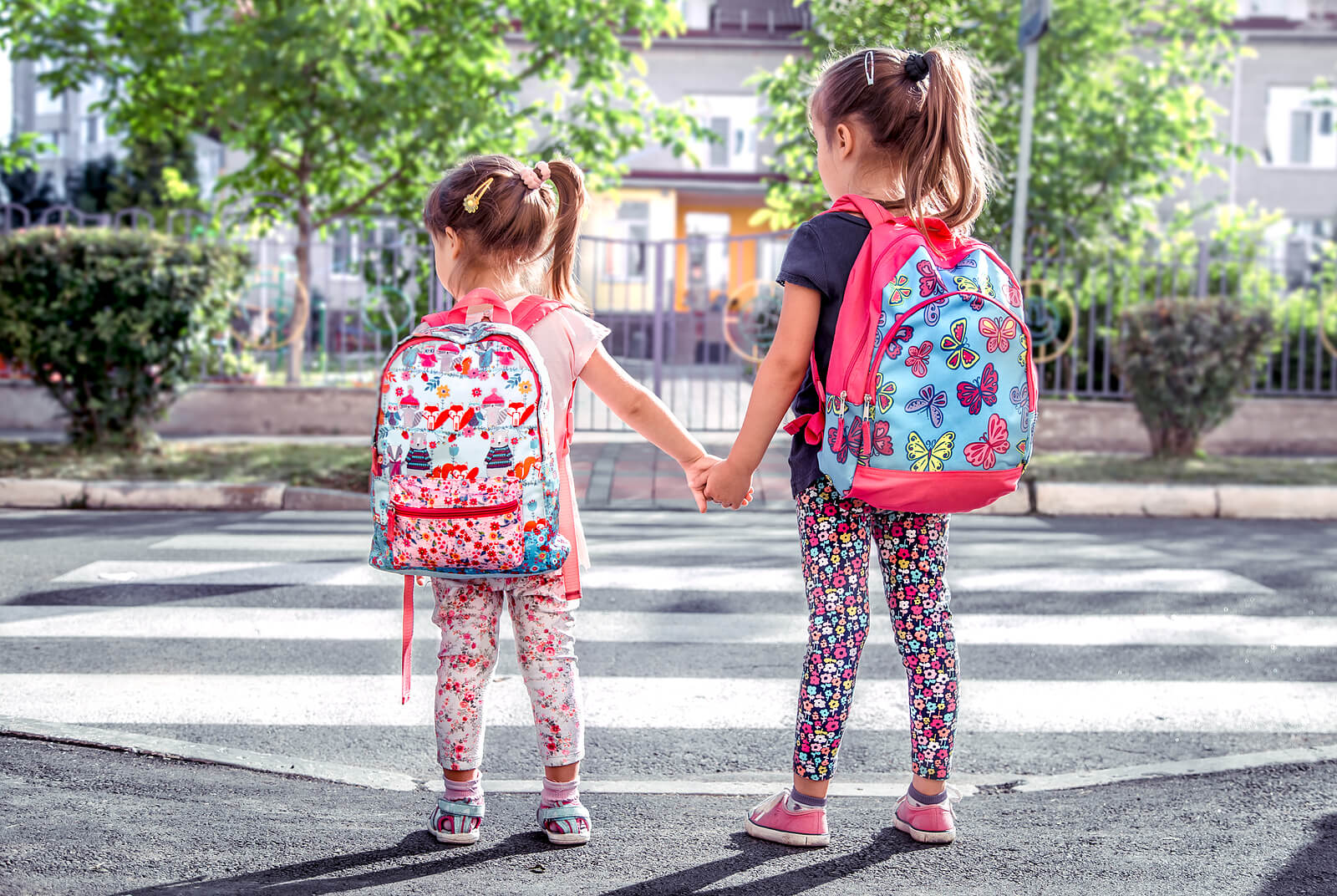 Meninas indo para a escola com suas mochilas.