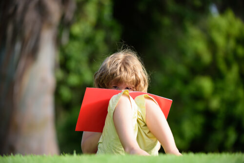 Niño al aire libre con un cuaderno de pasatiempos.