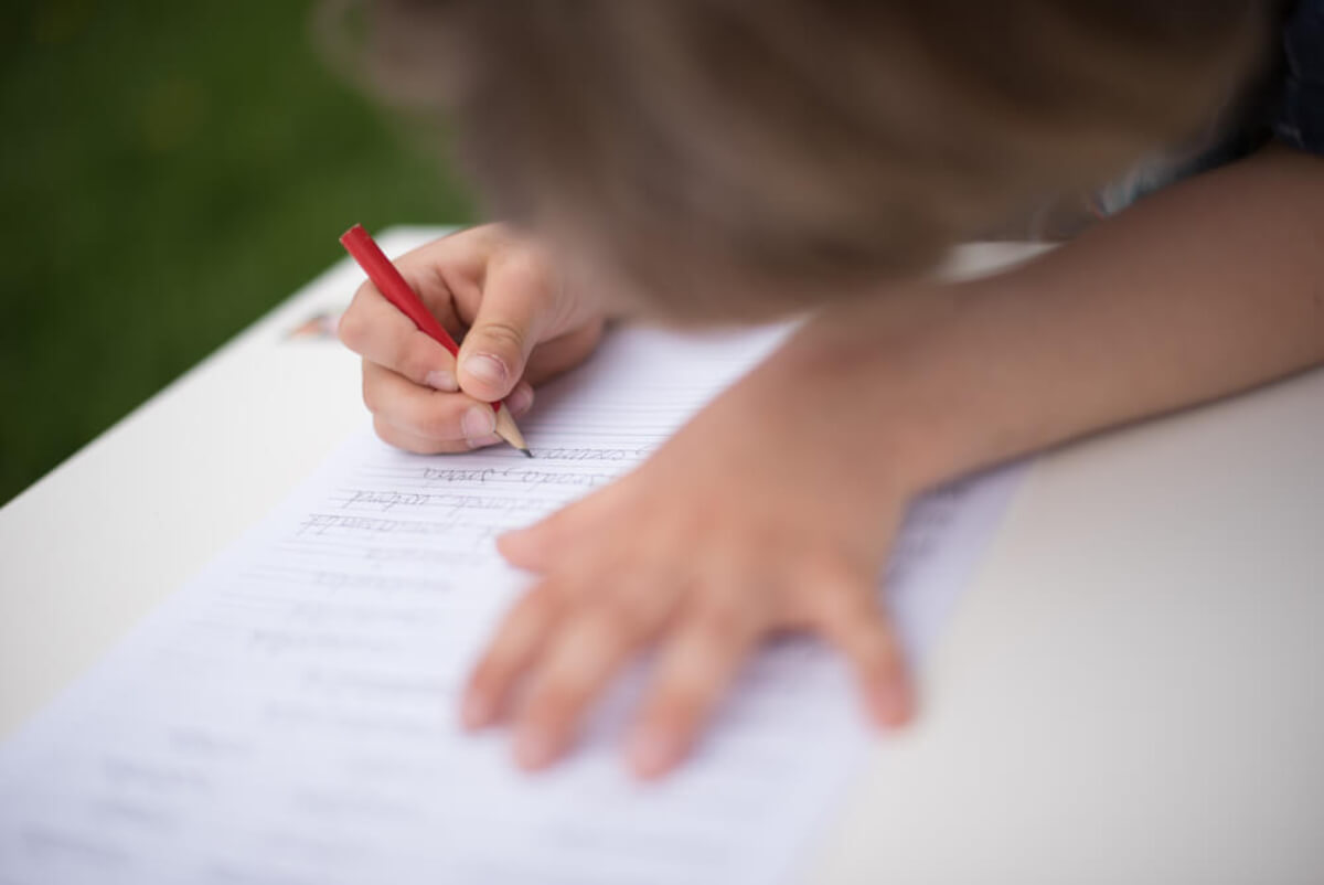 Niño aprendiendo a escribir gracias a la pauta Montessori.
