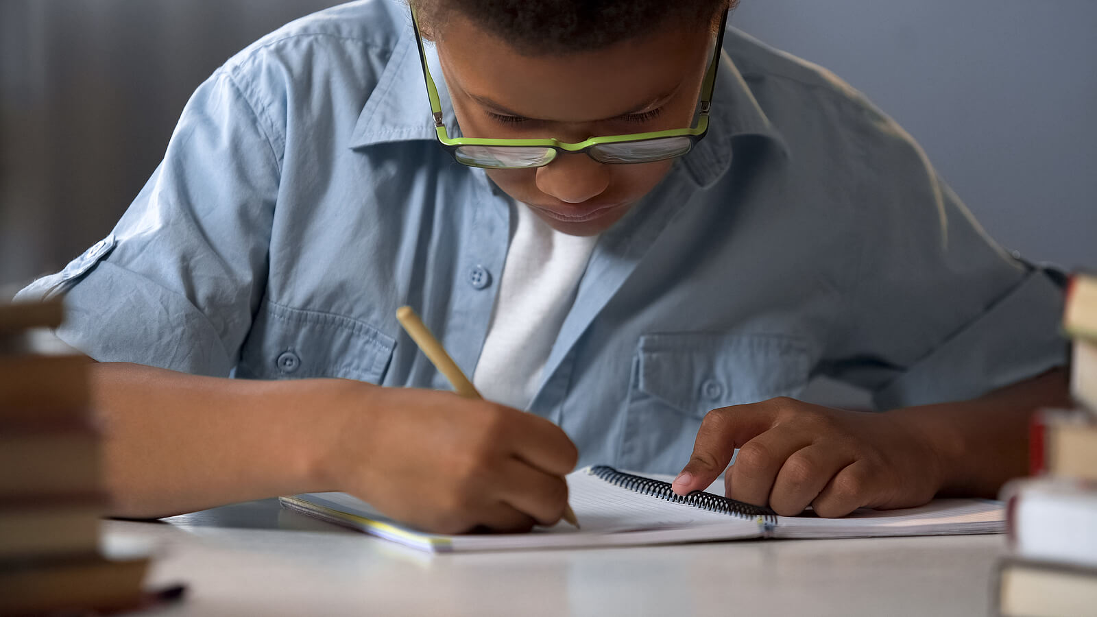 Niño con disortografía escribiendo en un cuaderno.