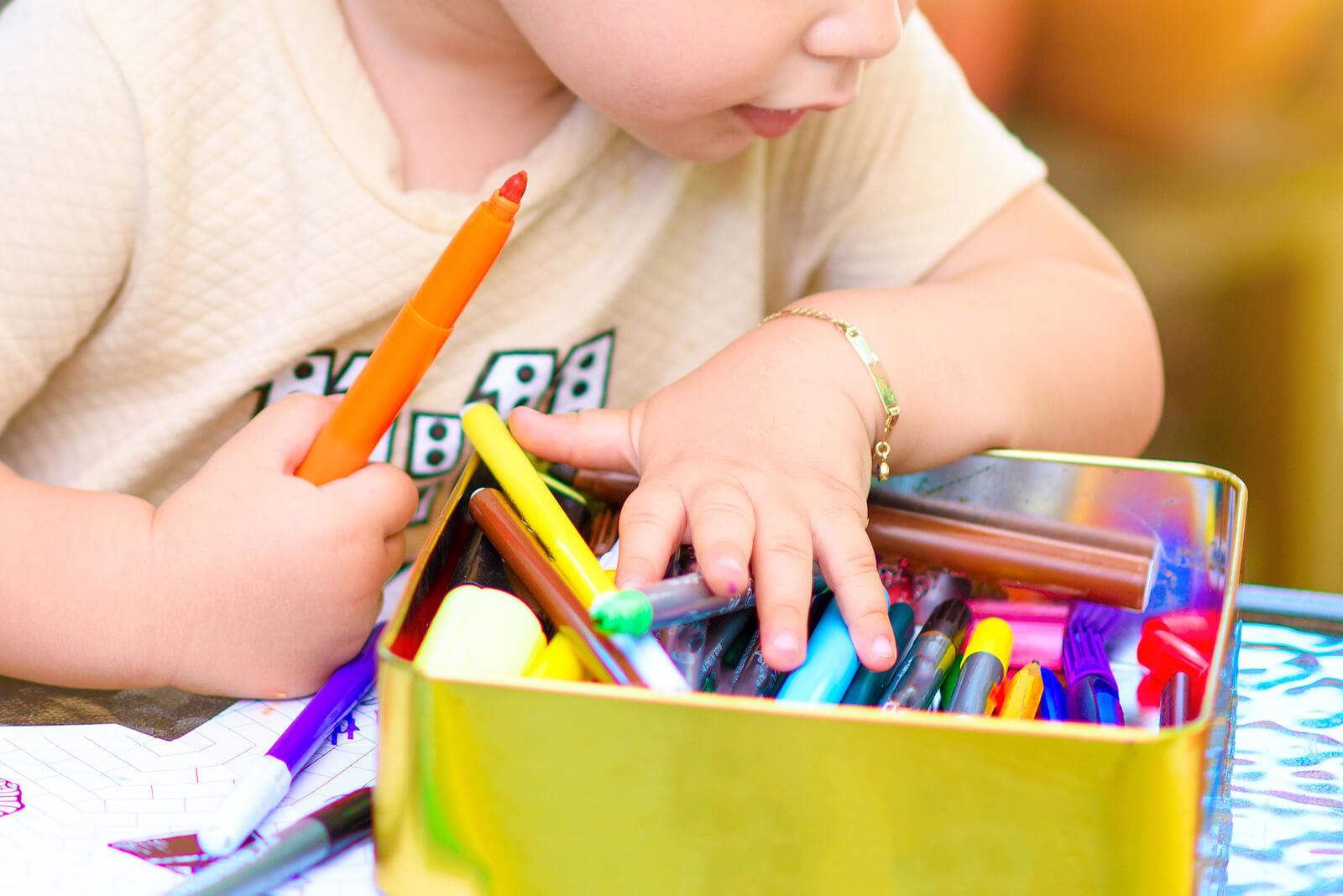Niño haciendo un dibujo con rotuladores de colores.