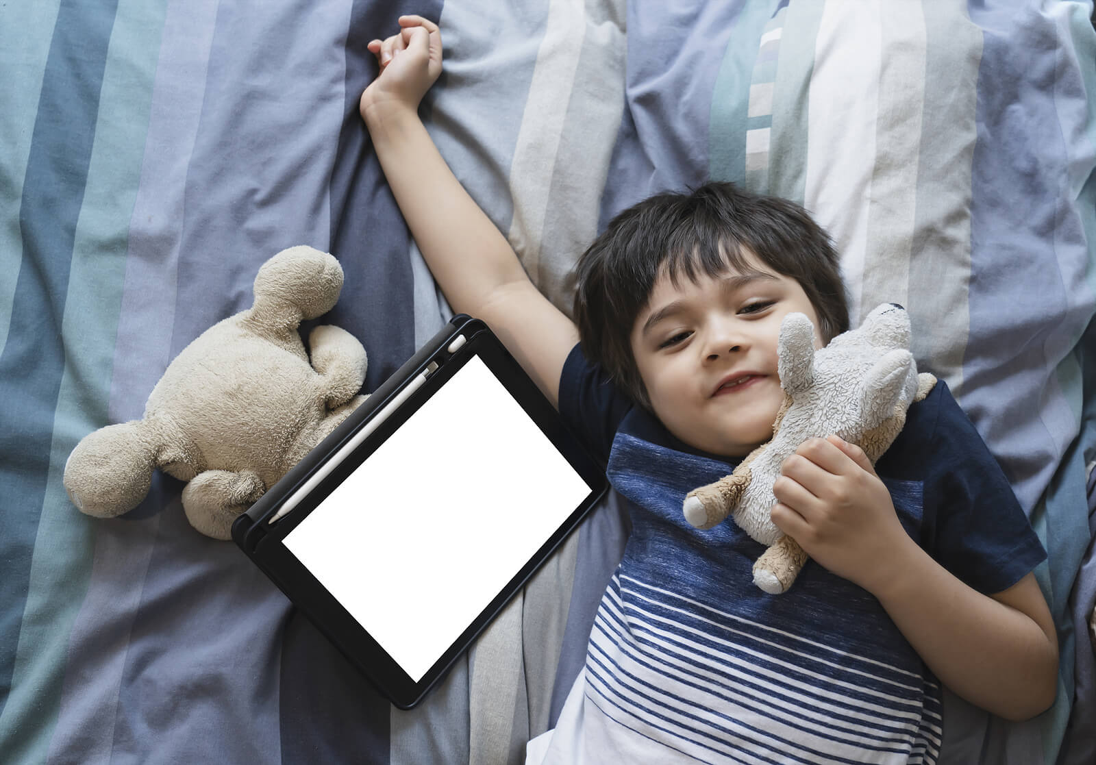 Niño usando una tablet antes de dormir, uno de los errores que cometemos al acostar al niño.