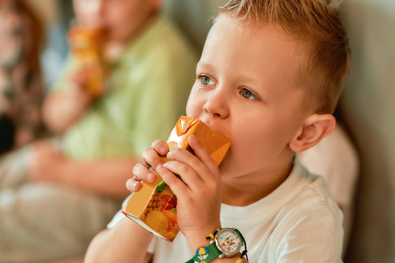 Un garçon qui boit un jus de fruit.