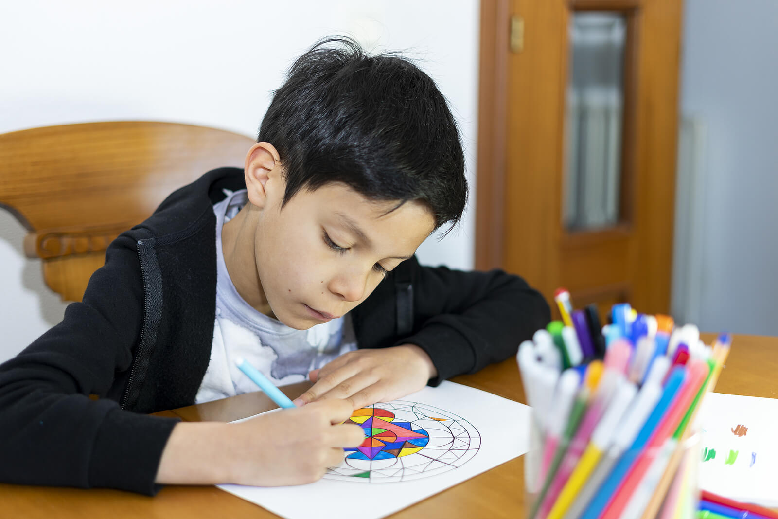 Niño pintando mandalas, uno de los métodos de relajación para niños por edades.
