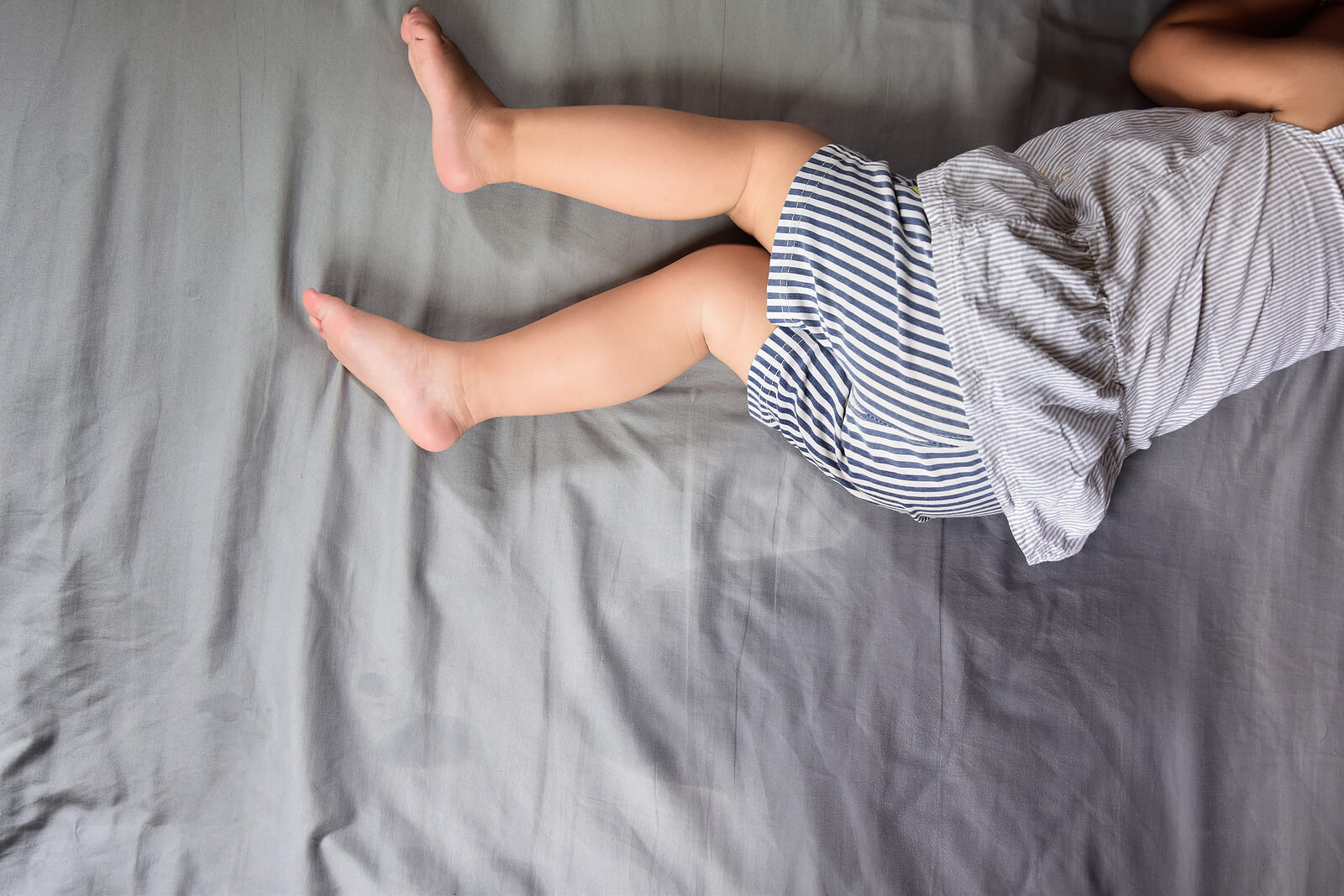 Niño con la cama mojada porque sufre regresiones infantiles.