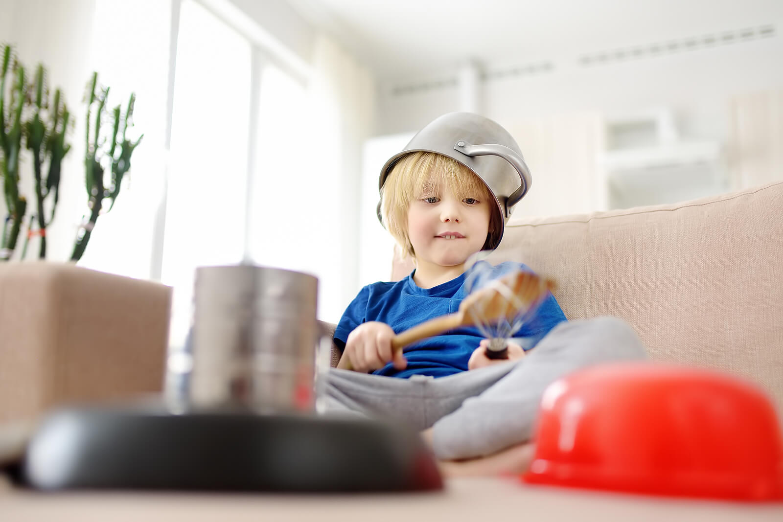 Un enfant qui joue avec des ustensiles de cuisine.