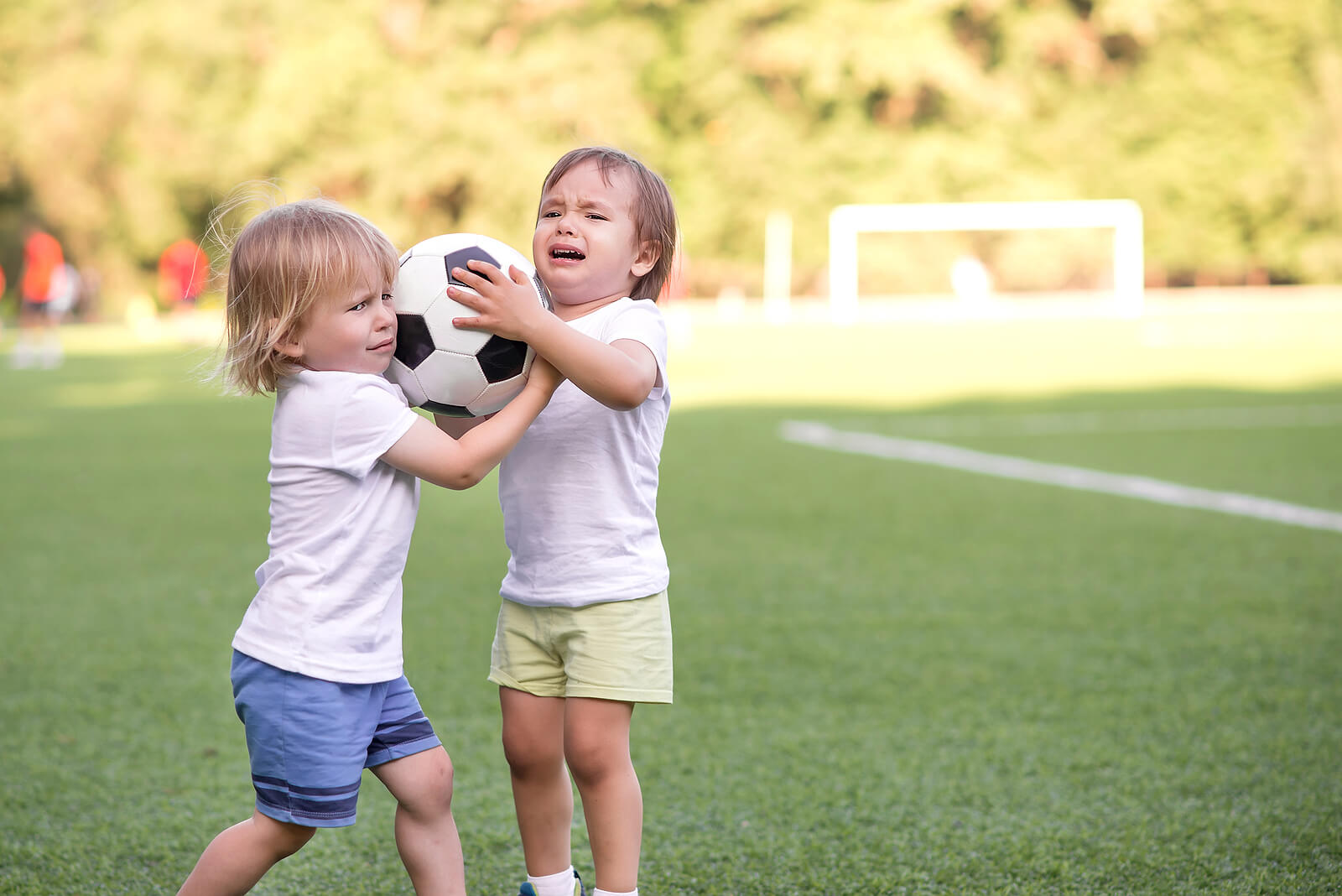 Niños peleando por un balón de fútbol.