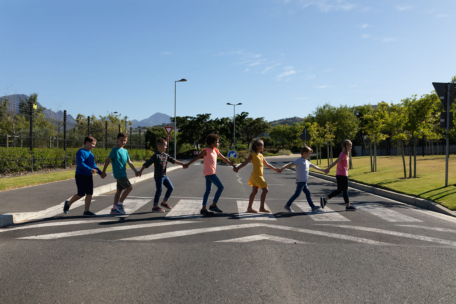 Niños de la mano cruzando un paso de peatones.