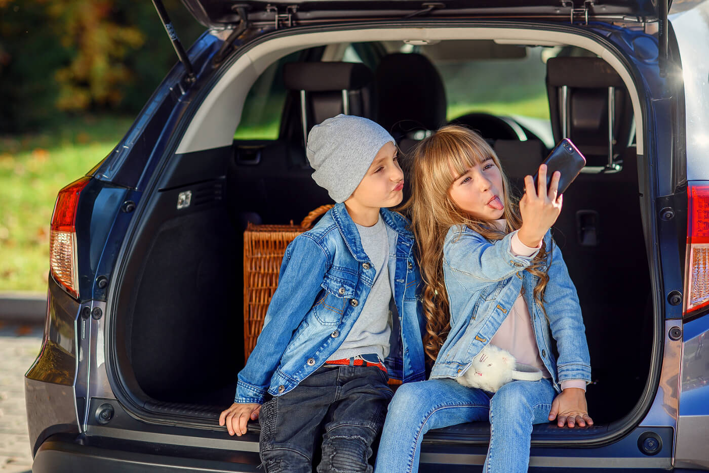 Niños entre los 10 y los 12 años haciéndose un selfie en el coche.
