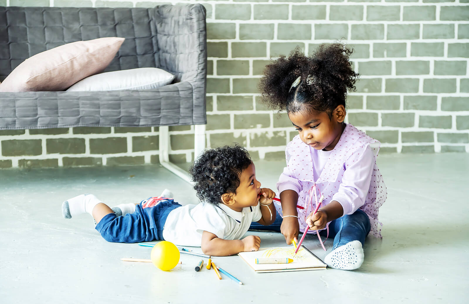 Niños hermanos haciendo manualidades en casa.