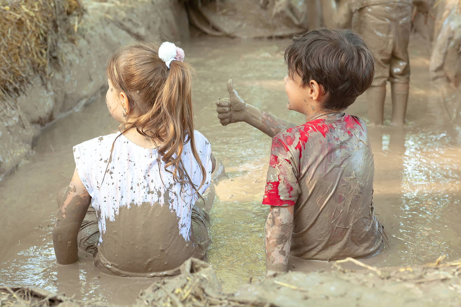Niños en una piscina de barro aprendiendo a soltar el control.