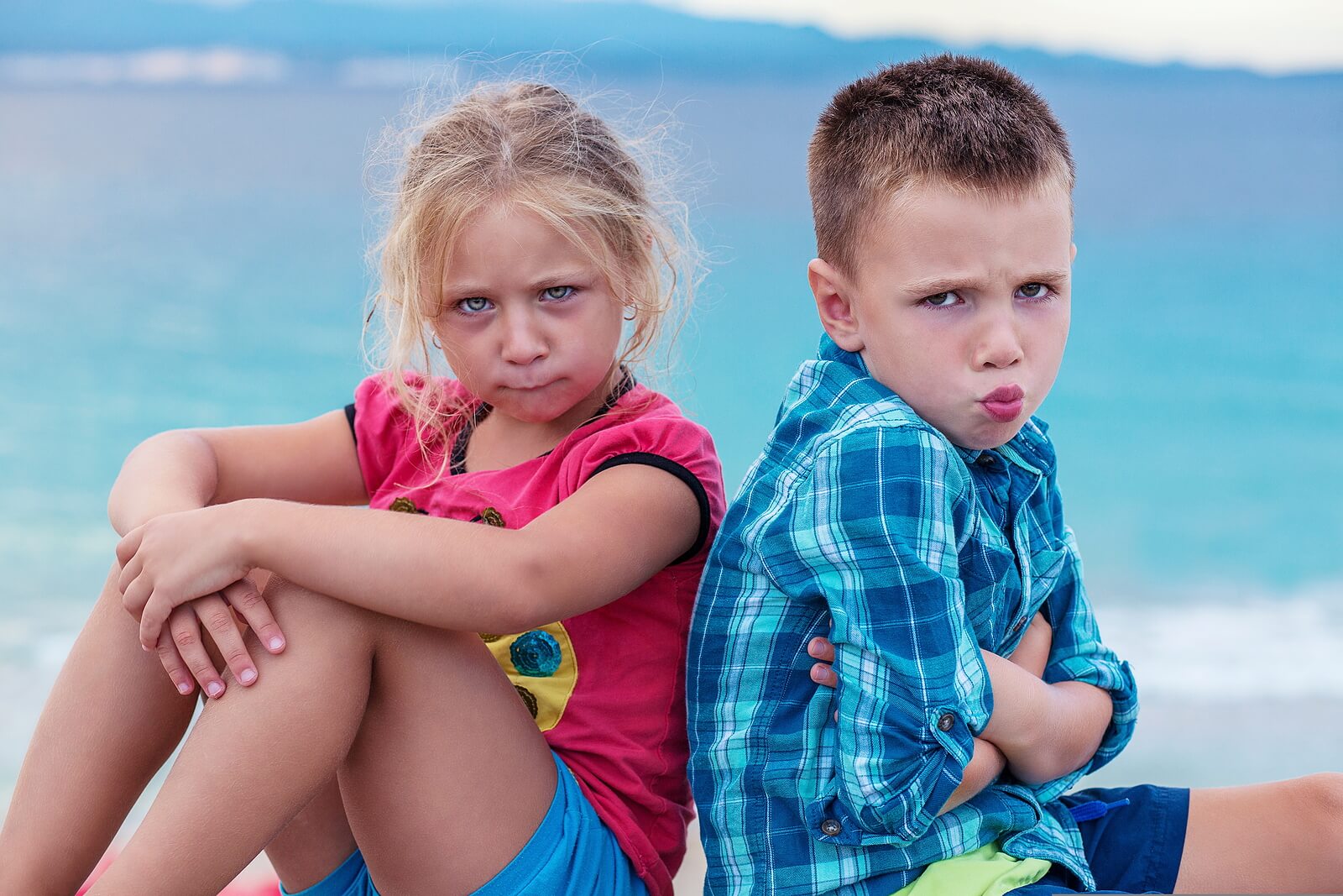 Niños sentados en el suelo peleados porque no saben resolver conflictos.