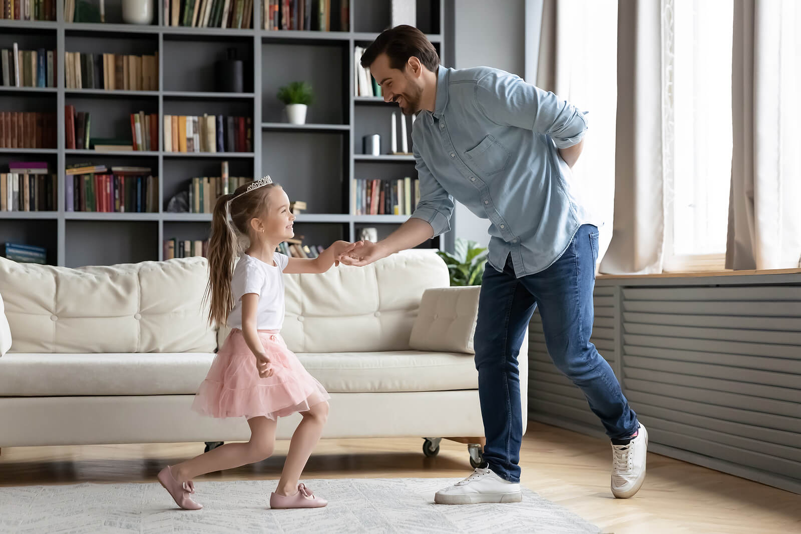 A father bowing to his daughter as she curtsies.
