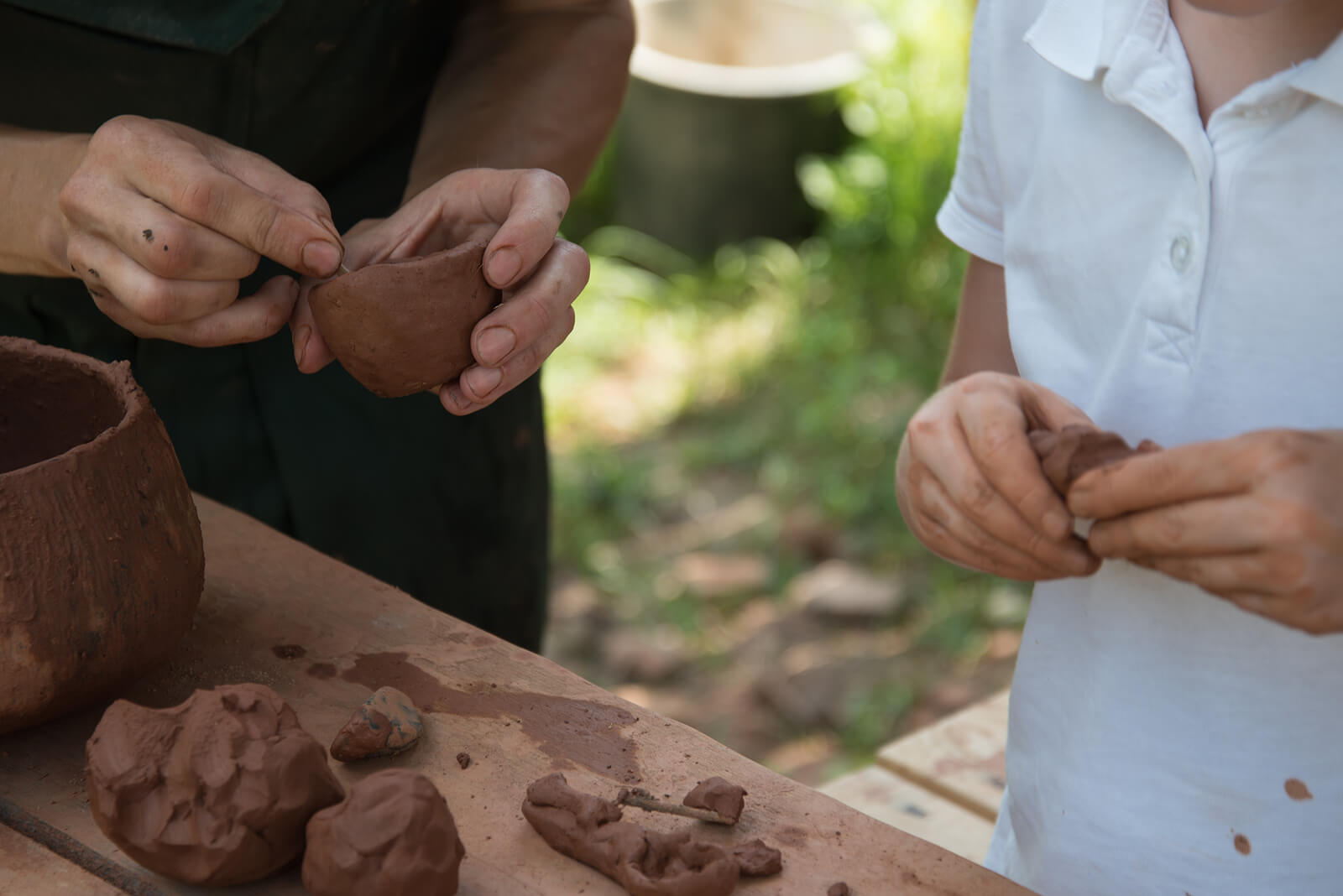 Padre e hijo haciendo figuras con barro.