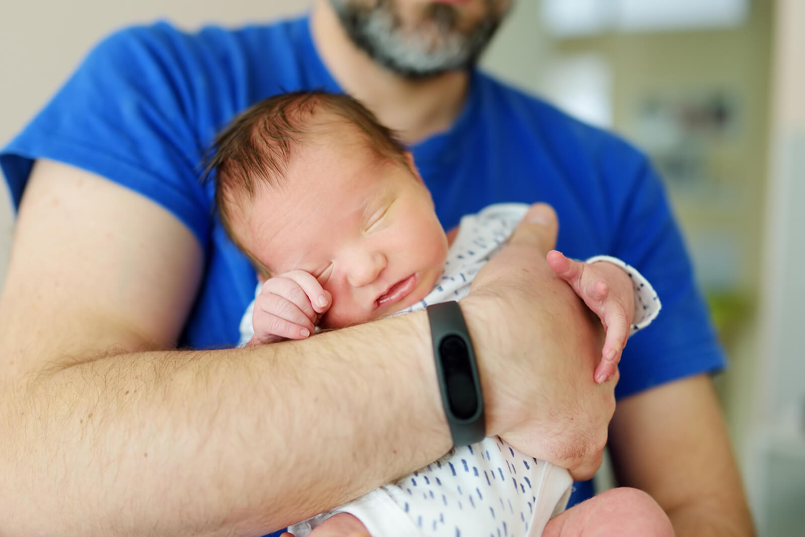 Papá con su bebé recién nacido en brazos.