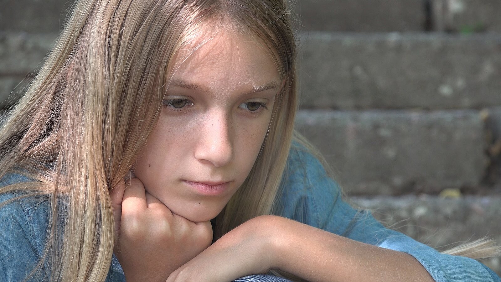 A teenage girl looking pensive.