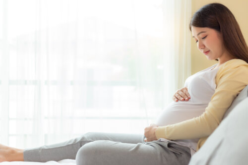 Mujer embarazada mirando su barriga.