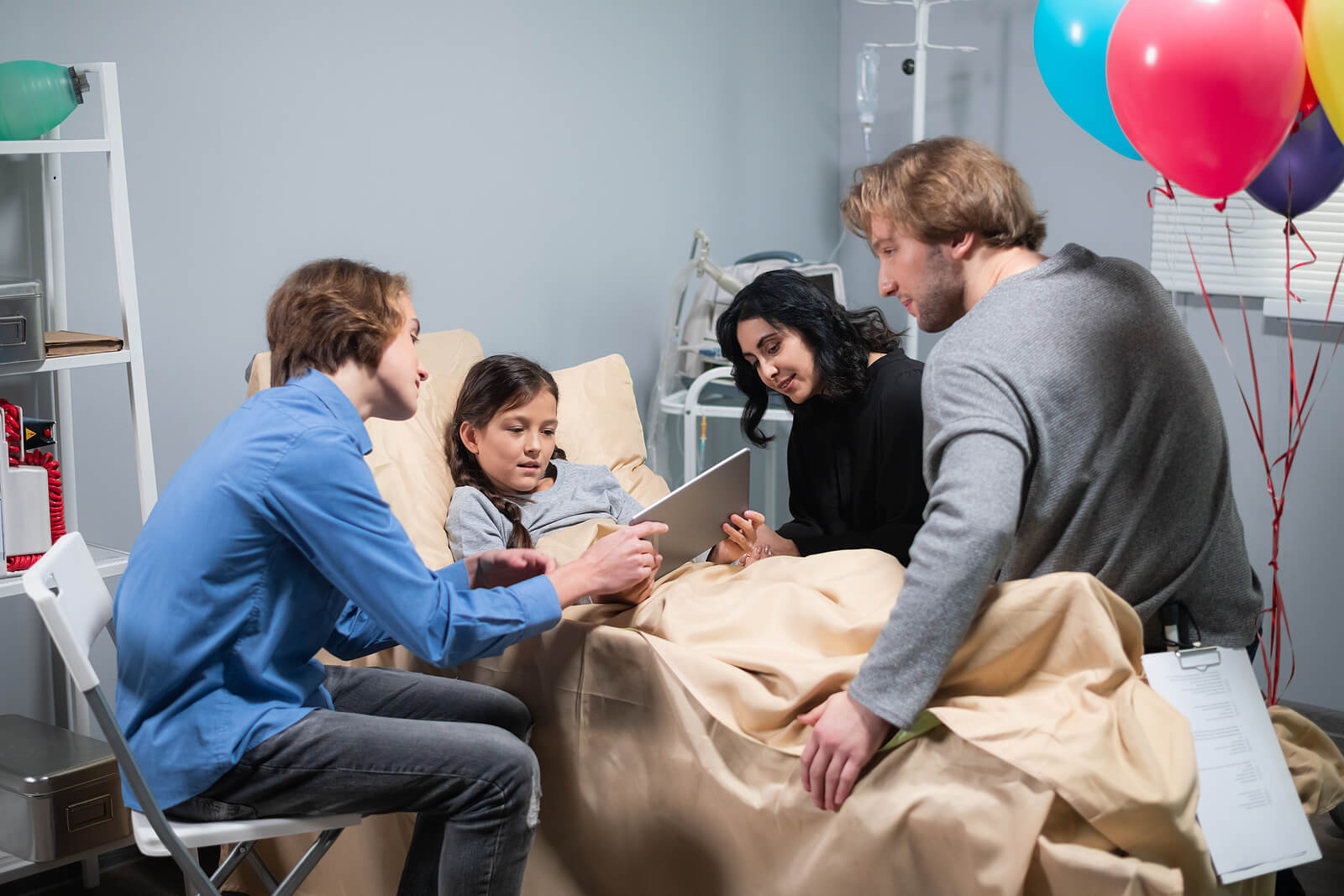 Niña enferma recibiendo visita de su familia en el hospital.