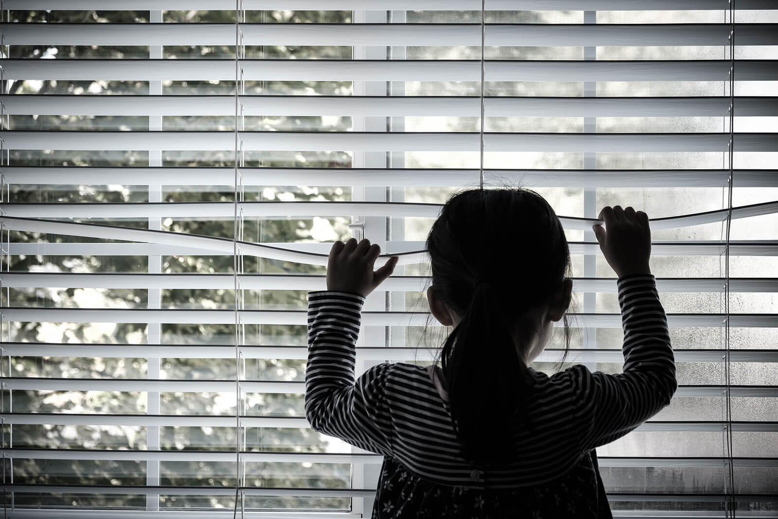 Une jeune fille regardant par la fenêtre.