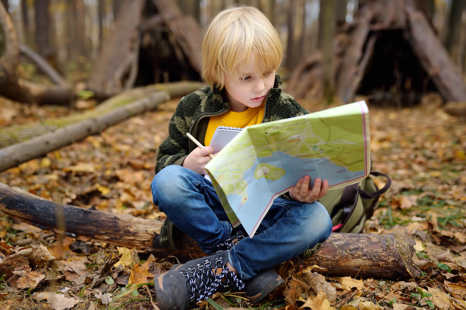 Garçon dans les bois avec une carte dans le cadre de l'une des activités cartographiques.