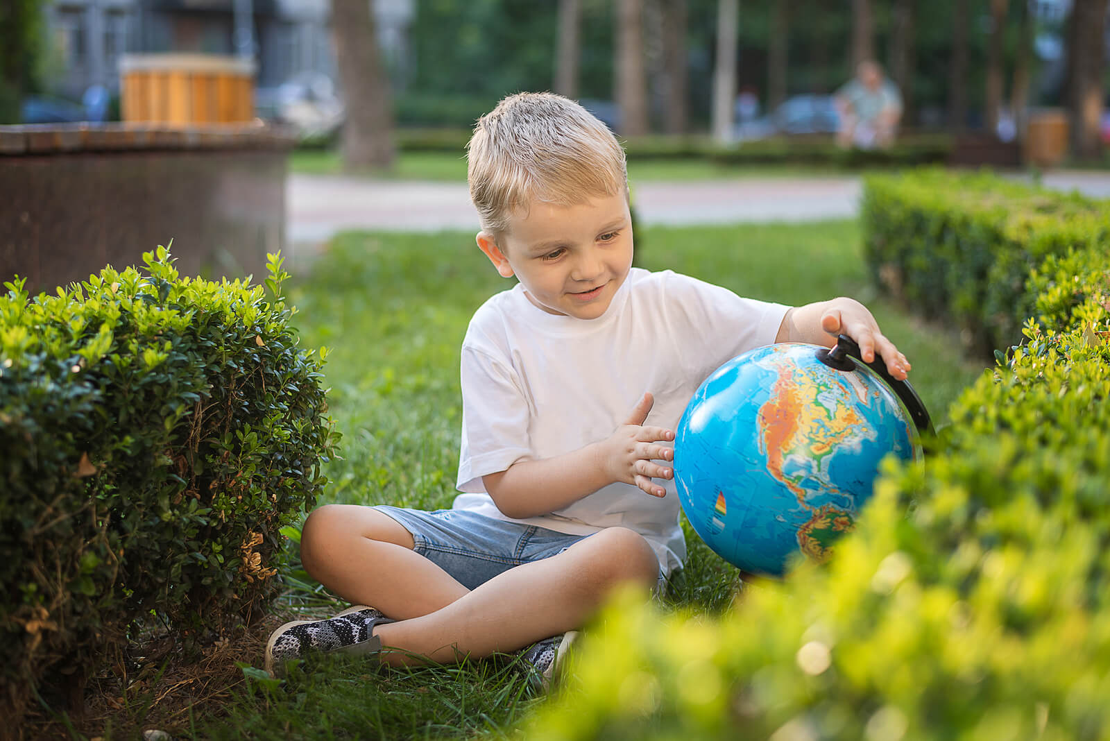 Niño aprendiendo a leer un globo terráqueo.