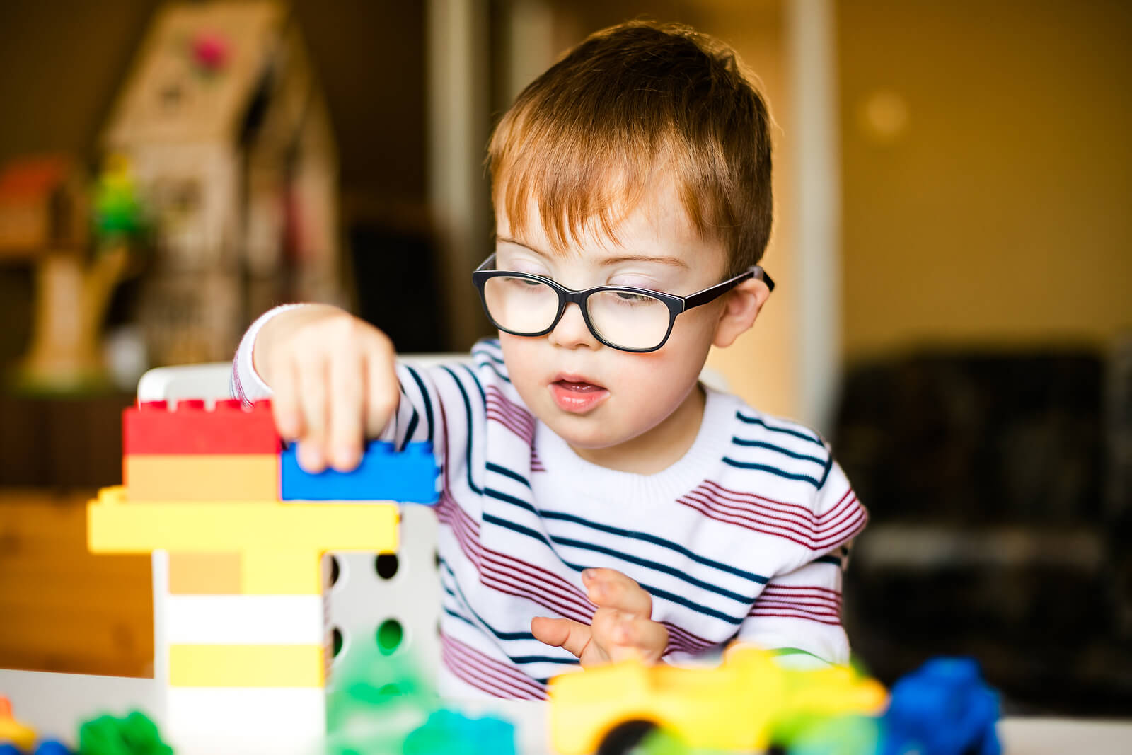 Niño con síndrome de Prader Willi jugando a las construcciones.