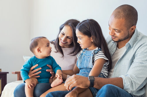 Padres abrazando a sus dos hijos.