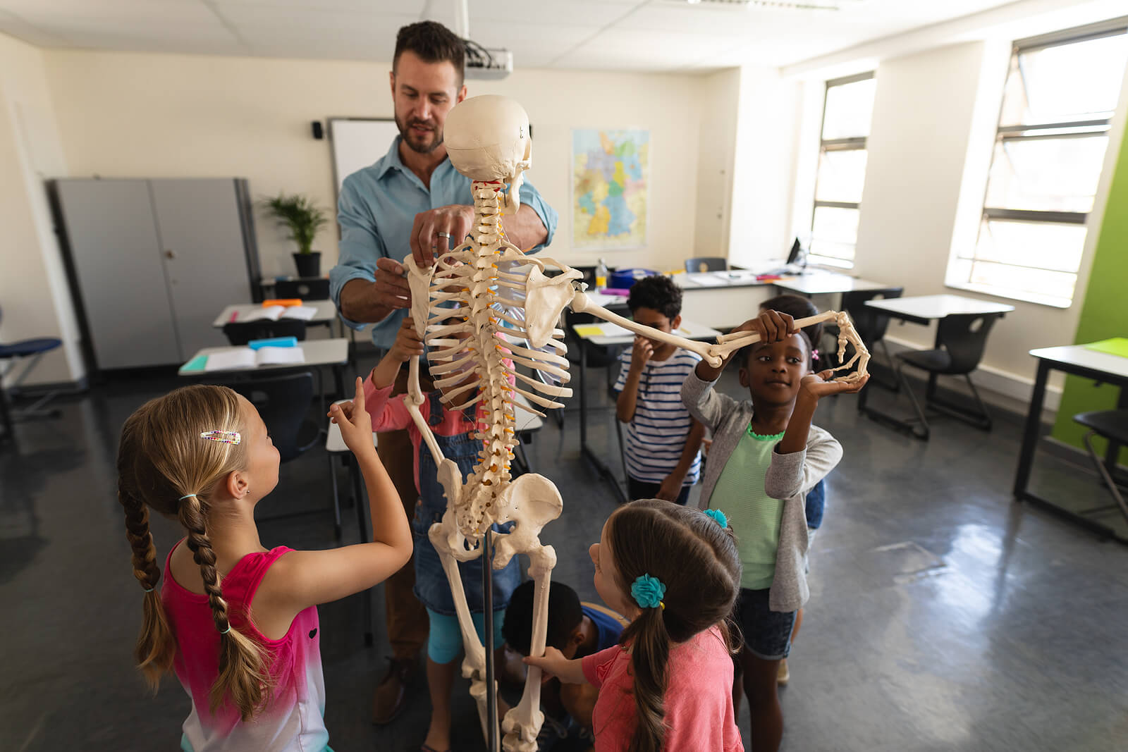 Profesor explicando el cuerpo humano con un esqueleto.