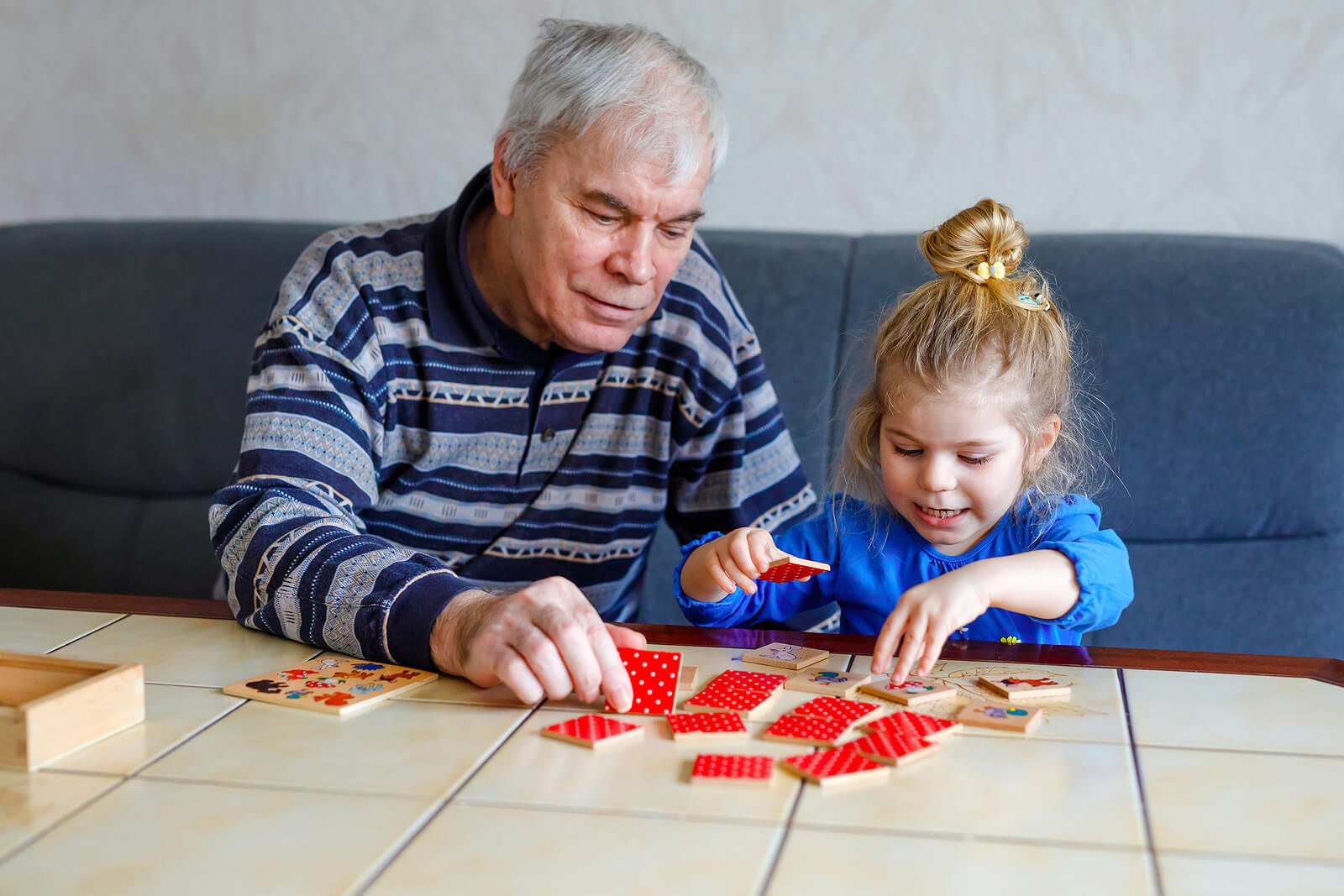Abuelo con su nieta jugando a juegos para estimular la memoria de trabajo.