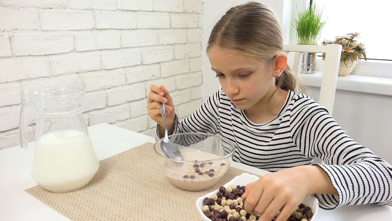 Adolescente desayunando cereales con cacao soluble.