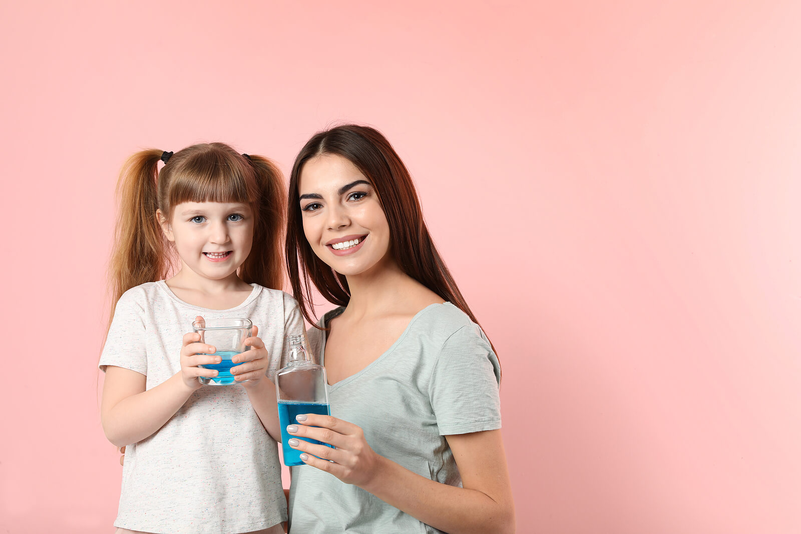 Madre e hija llevando a cabo una rutina de enjuague bucal para niños.