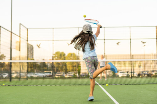 Niña jugando al tenis.