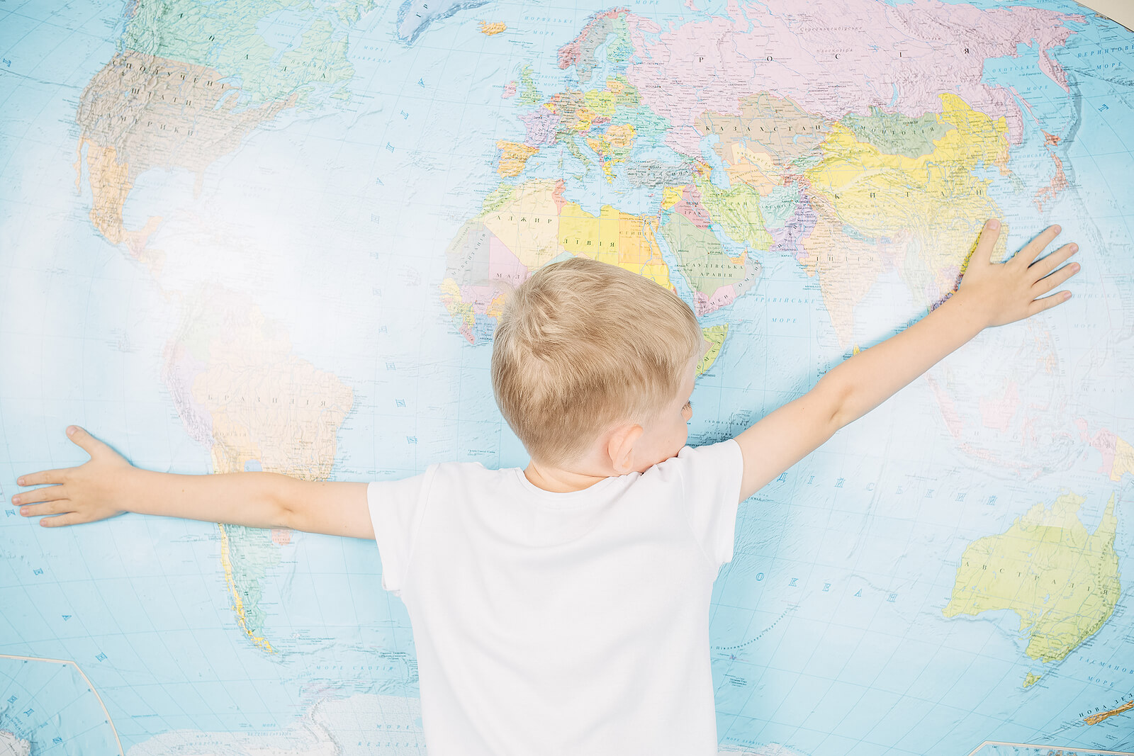 Niño abrazando un mapamundi infantil.