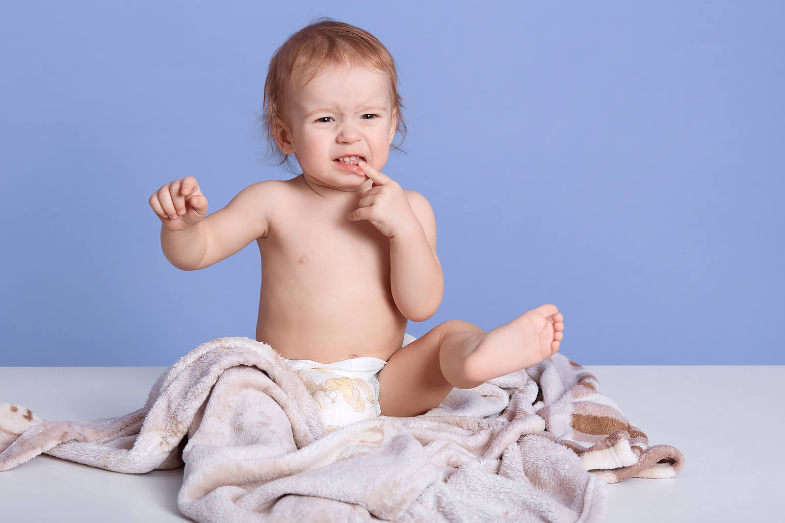 Niño con una manta alrededor para cuidar su piel seca.