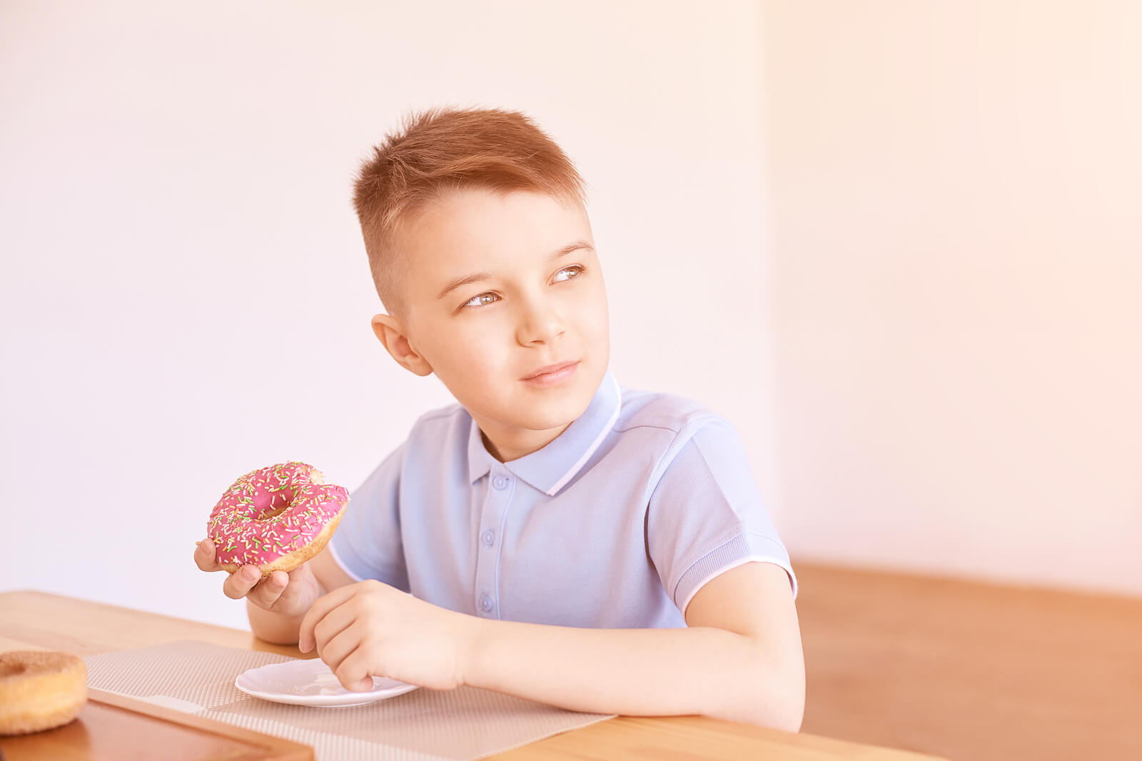 A young boy eating a donut.