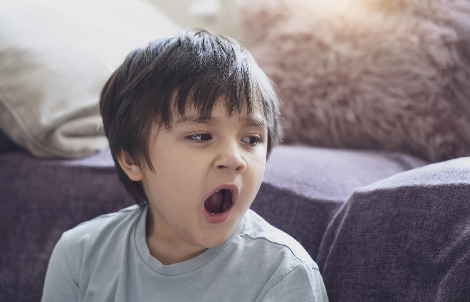 Niño cansado bostezando.