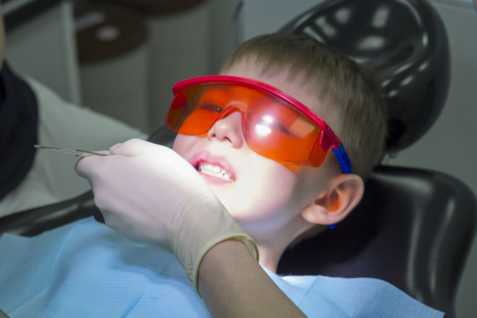 Niño al que le están haciendo empastes en los dientes de leche en el dentista.