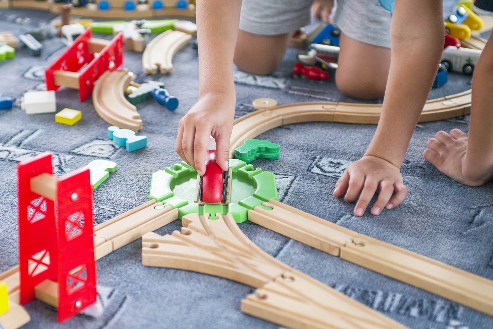 Niño jugando con trenes en su zona de juegos.