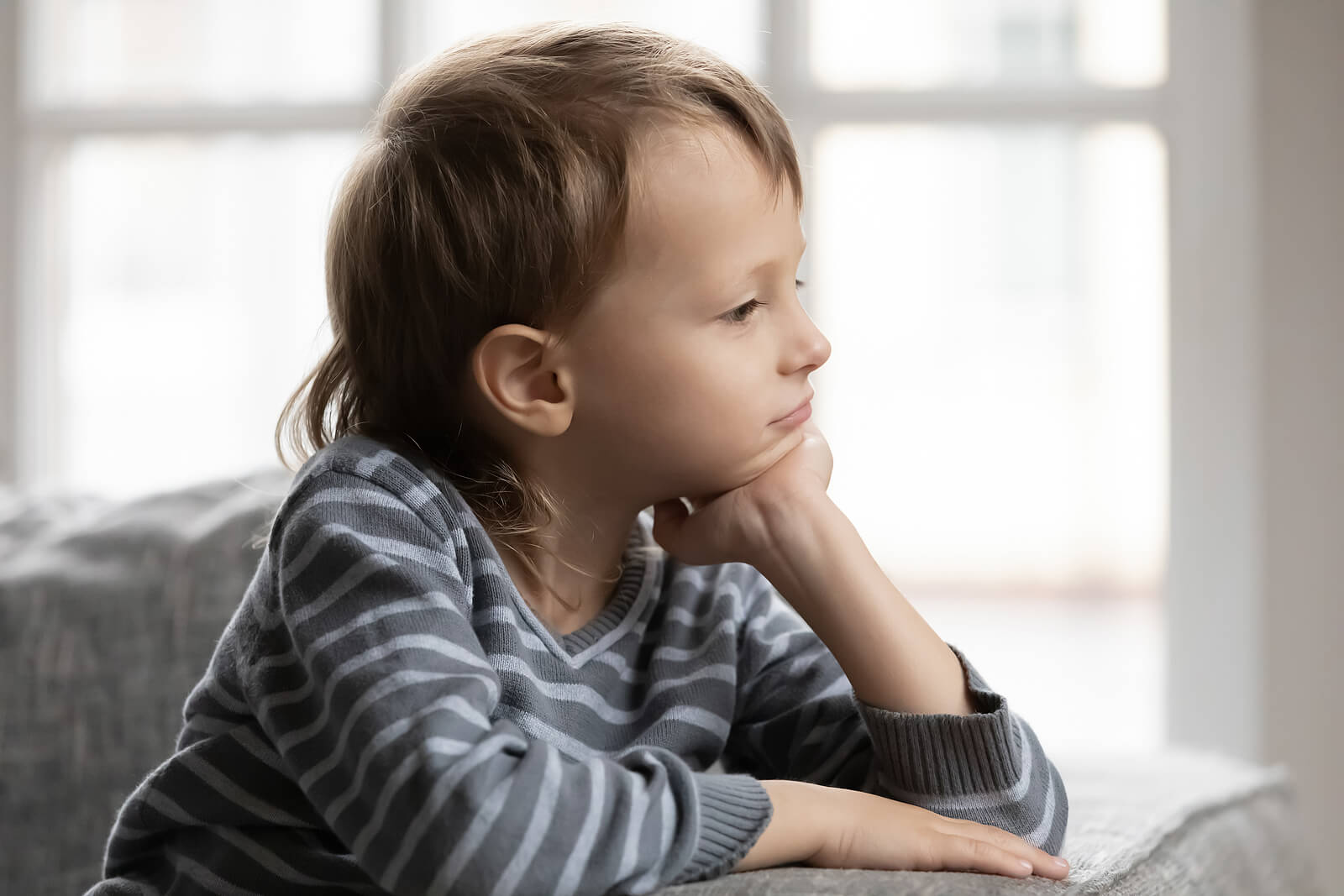 Niño pensativo buscando la aprobación de los demás.