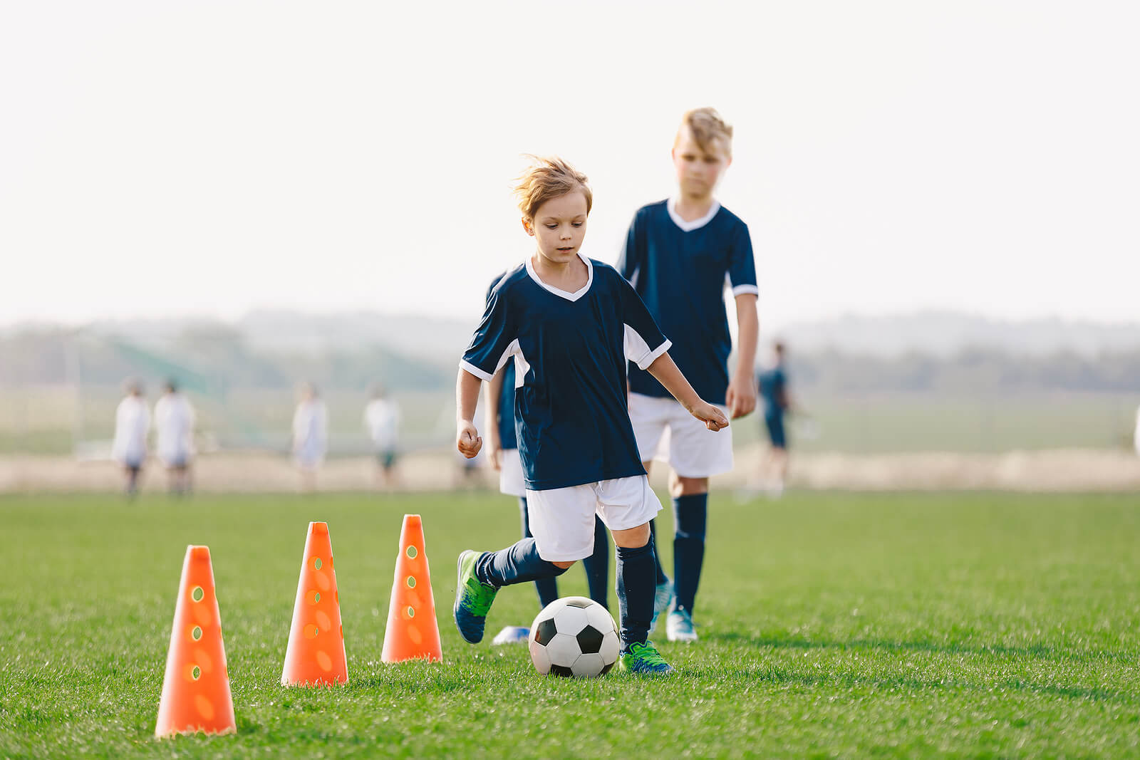 Chicos en un entrenamiento de fútbol para mejorar la psicomotricidad de los niños.