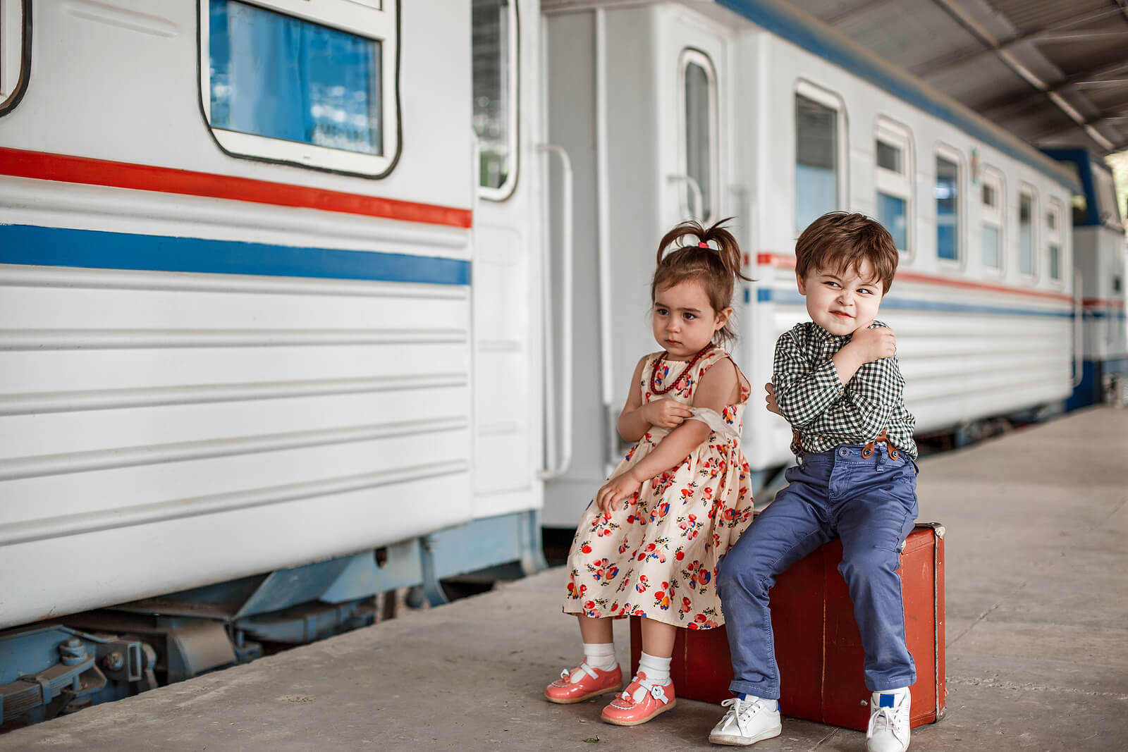 Niños con una maleta preparados para decir adiós.