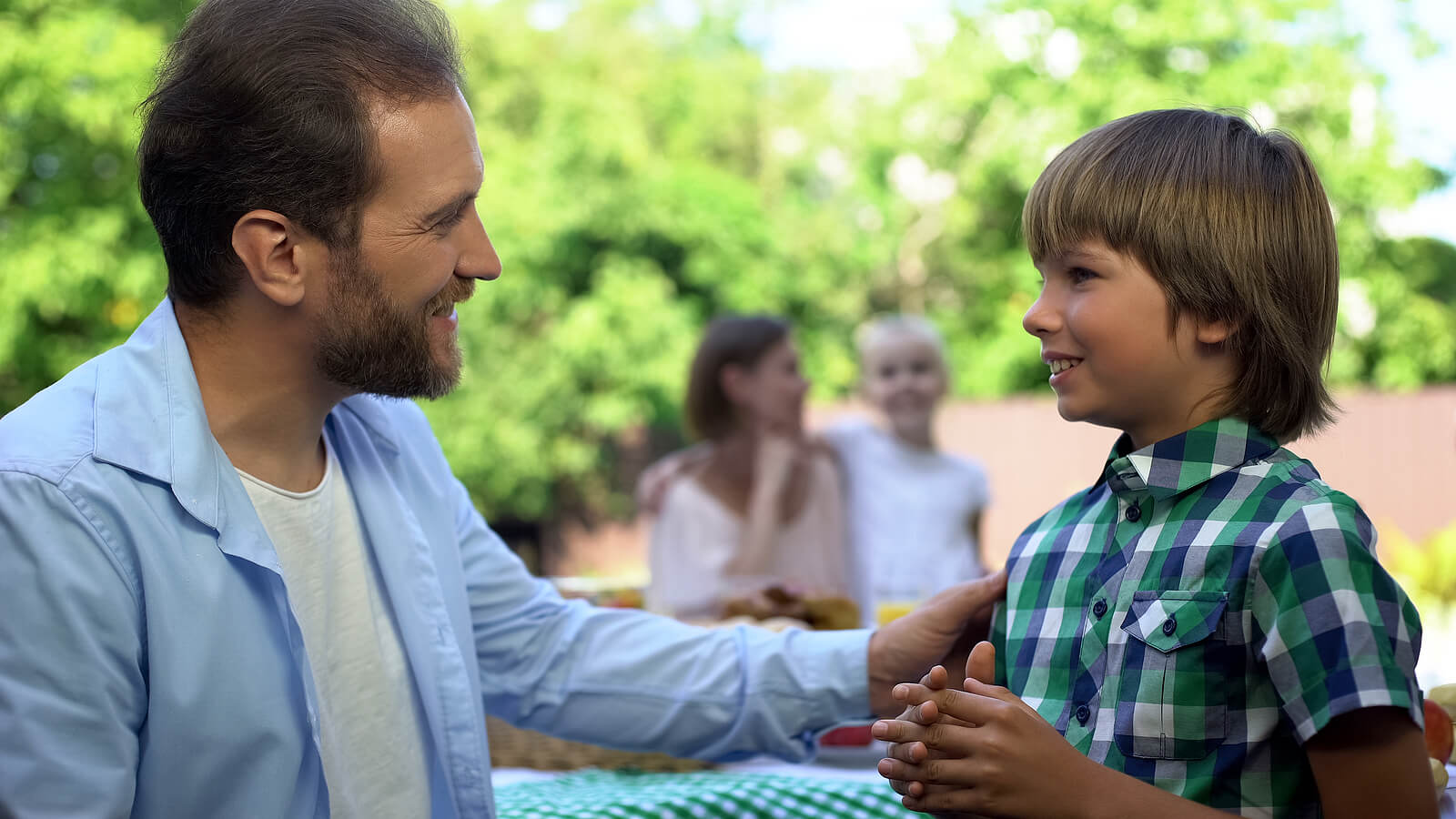 Padre hablando a su hijo con paciencia.