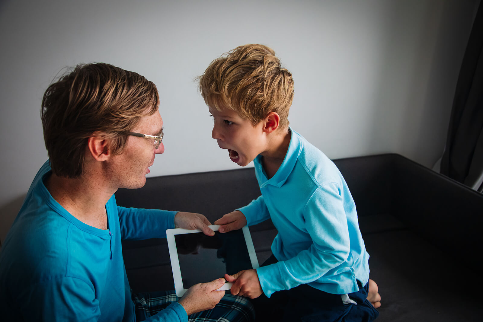 Padre e hija discutiendo por la tablet.