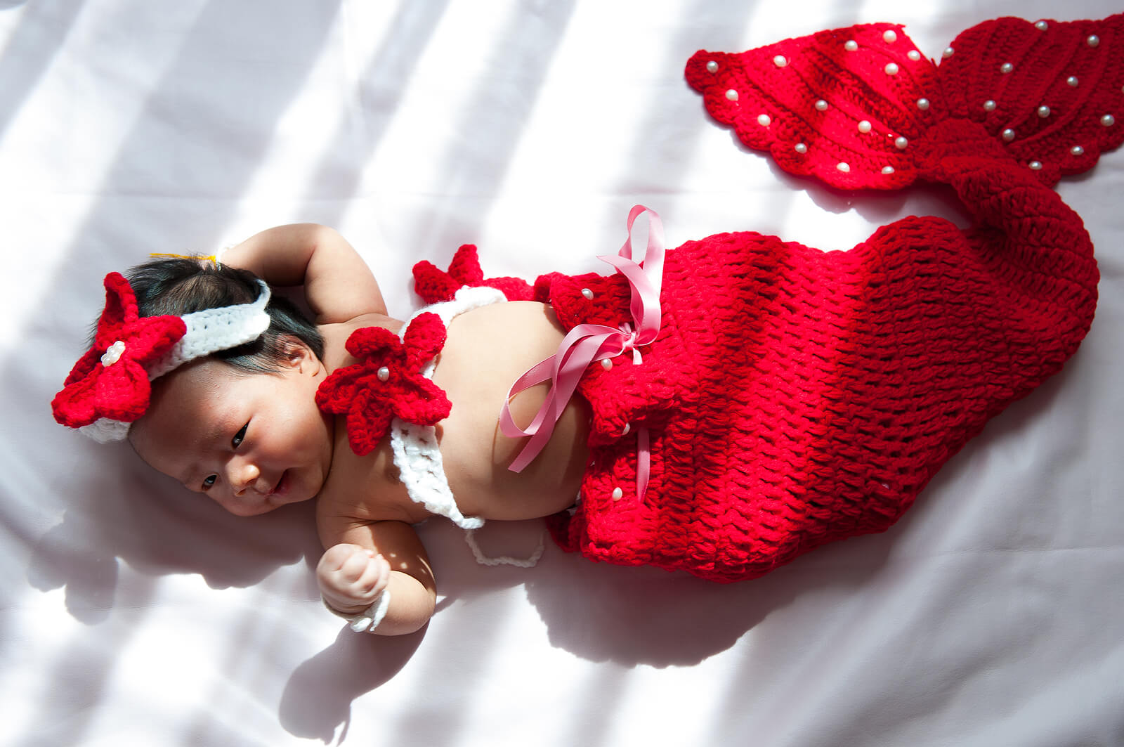 vom Meer inspirierte Babynamen - kleines Mädchen im Meerjungfrauenkostüm